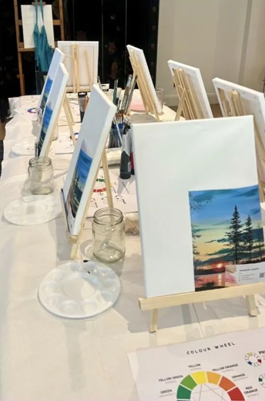 Easels, canvases and palettes set out before a workshop