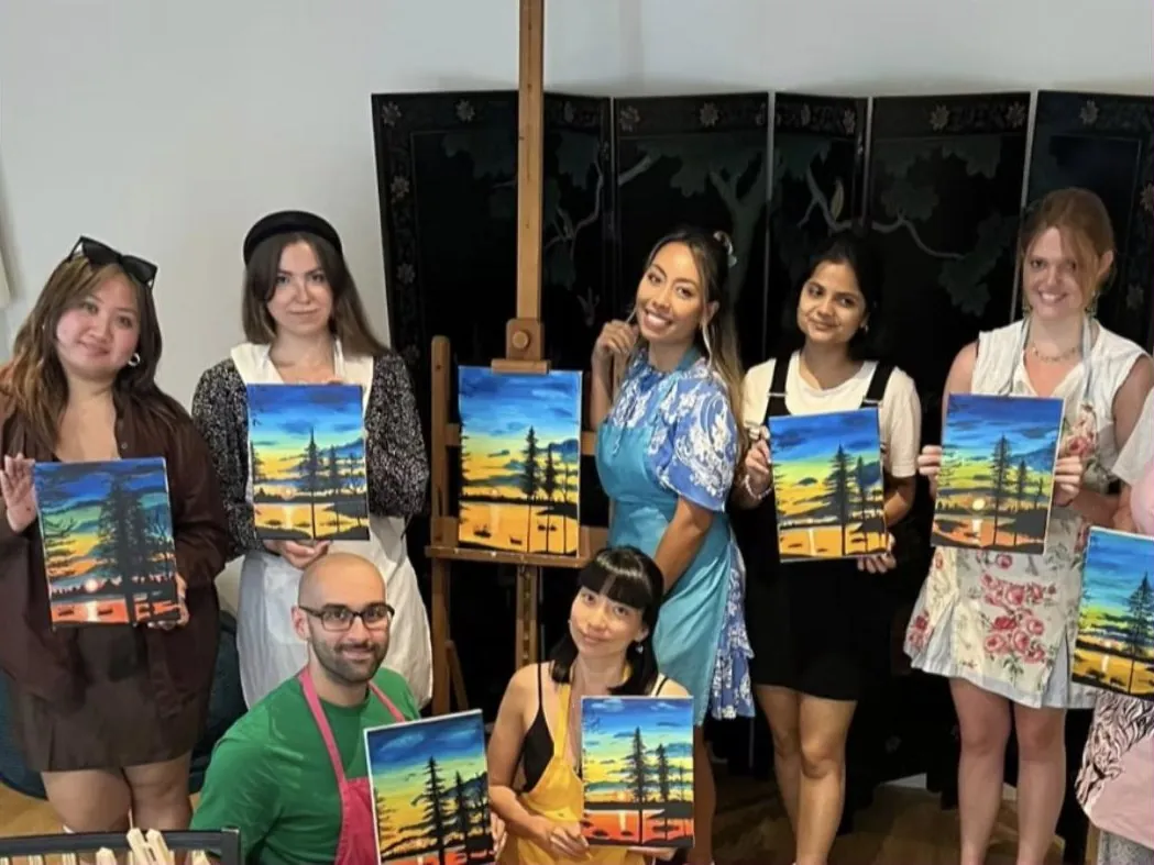 A workshop group holding up their finished paintings